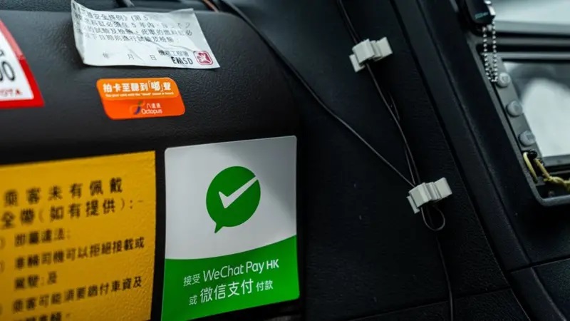 一辆香港的士上的微信支付（绿色）与八达通卡（橘色）标示